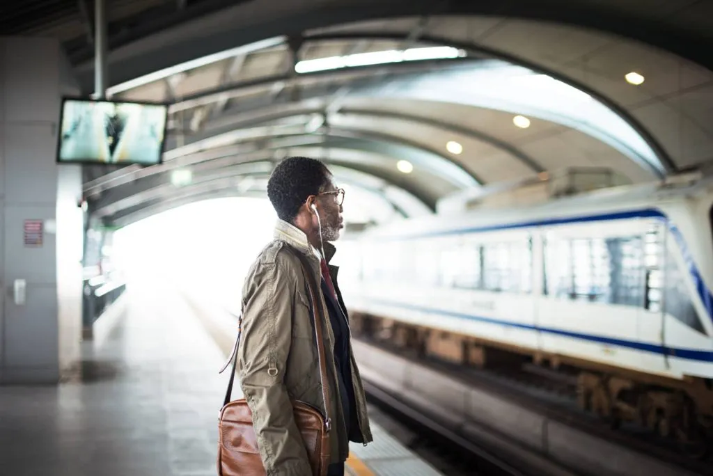 Commuter waiting on a rail platform as a train arrives