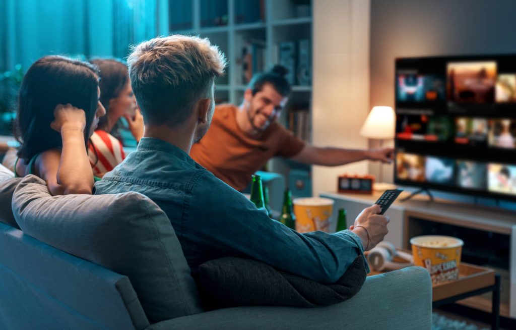 Friends watching television together at home