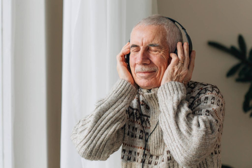 Older adult listening through over-ear headphones